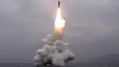 What appears to be a submarine-launched ballistic missile (SLBM) flies in an undisclosed location in this undated picture released by North Korea's official news agency