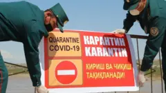 Карантин белгисини қўяётган милиция ходимлари