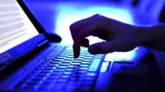 कम्प्युटर चलाइरहेको हात देखिने प्रतीकात्मक तस्बिर 