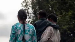 পরিচয় যাতে গোপন থাকে তা নিশ্চিত করতে পেছন থেকে তোলা আক্রান্ত শিশু ও তার অভিভাবকের ছবি