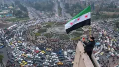 تظهر صورة جوية رجلاً سورياً يلوح بعلم "الثورة" السوري في ساحة الأمويين المركزية في دمشق في 11 ديسمبر/كانون الأول 2024.