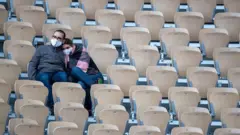 A couple cuddle to keep warm