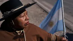 Una mujer sostiene una bandera argentina en un bloqueo de carretera en Purmamarca, junio 28 2023