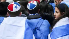 Dos jóvenes llevan una kipá con los colores de la bandera panameña.