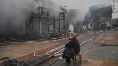 Продавчиня сидить на місці ринку Барабашово, що постраждав від удару російського безпілотника Харків, Україна, 6 травня 2025 року