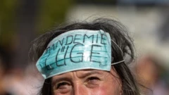 Mulher manifestante em Berlim usa máscara, colocada na testa, que diz: 'Mentira da pandemia'