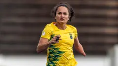 Atleta Fernanda Yara correndo durante treino usando camisa amarela e verde