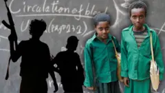 ከጀርባቸው ታጣቂዎች የሚታዩ እና ደብተር የያዙ ሁለት ተማሪዎች 