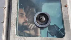جنود إسرائيليون ينظرون من داخل مركبة عسكرية خلال مداهمة.
