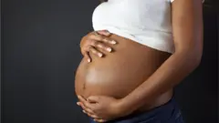 femme enceinte se tenant le ventre