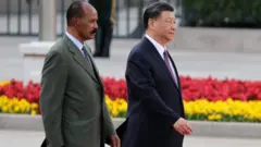 ኢሳይያስ ኣፈወርቂን ሺ ዢንፒንግን ኣብ ቀይሕ ምንጻር እናሰጎሙ፡ ኣብ ድሕረባይታኦም ብጫን ቀይሕን ዕንባባታት ይርአ