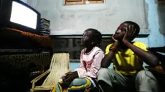 ቴሌቪዥን የሚመለከቱ ወንድምና እህት