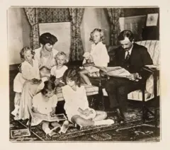 Carlos y Zita con 5 niños en la sala de una casa