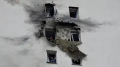 Na zdjęciu widać wielopiętrowy budynek mieszkalny uszkodzony w ataku ukraińskiego drona