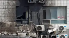 A view of broken windows and burned air conditioners following a fire at the Changfeng Hospital in Beijing