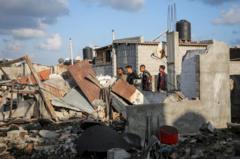 Palestinos inspeccionan casas dañadas en un ataque israelí en Rafah.