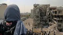 Женщина стоит спиной к камере на фоне разрушенных зданий в Тегеране, Иран, 20 апреля 2026 года