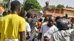 A large crowd of men protesting outside the French embassy in Niamey