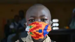 ጭምብል ያደረገ ታዳጊ