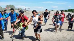 Migrantes corriendo para cruzar el río Suchiate-