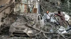 Мушкарац и жена пролазе кроз рушевине у украјинској престоници Кијеву