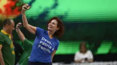 Carla Zambelli faz uma "selfie" vestida com uma camiseta azul escrito "Deus, pátria e família".