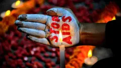 Wani mai fafutuka ya fenta hannunsa da rubutun a kawar da cutar HIVe during an awareness campaign organized to observe World Aids Day