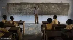 Olùkọ́ tó ń kọ iṣẹ́ sójú pátákó ìkọ̀wé 