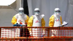 Health workers wear protective suits for one Ebola treatment centre inside DR Congo