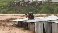 ललितपुरको नक्खु खोला किनाराको टहरोमाथि उद्धारको पर्खाइमा रहेका मानिसहरू, पछि खोलाले उनिहरू सबैलाई बगायो। चारमध्ये तीन जनाको केही तलबाट घाइते अवस्थामा उद्धार गरिएको अधिकारीहरूले बताएका छन् 