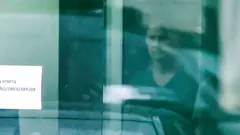 Jair Bolsonaro por trás da porta de vidro da Superintendência da Polícia Federal de Brasília neste domingo.