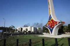 نصب السيف الدمشقي وخلفه يظهر دخان ناتج عن غارة إسرائيلية. الصورة التقطت نهاراً.