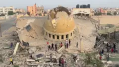  فلسطينيون يتفقدون آثار تدمير مسجد بخان يونس