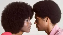 Casal com cabelo black se olhando de frente