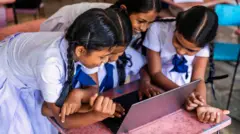 Sri Lankan school children using a laptop in a classroom, Sigiriya, Ceylon.