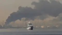 سفينة ومن ورائها على السواحل دخان كثيف