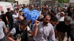 فلسطينيون يشيعون جثمان أحد القتلى.