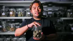 대마꽃이 들어있는 병을 들고 있는 남성