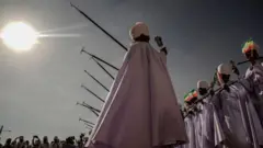 Manayn malaman Kiristoci na rike da tutoci suna rera waƙa a wajen bikin a birnin Addis Ababa, Habasha.