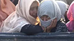 Dua perempuan etnis Rohingya yang menangis saat kapalnya akan ditarik ke darat oleh kapal nelayan Aceh, Kamis (26/06).