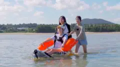 직접 구매한 수중휠체어를 시범 운영해보고 있는 제주 표선고 인권동아리 '이끼' 부원들