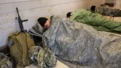 Members of the National Guard rest in the Capitol Visitor Center on Capitol Hill in Washington,