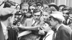 Los mensajeros de las casas de bolsa se agolpan en torno a un periódico tras el primer desplome de la bolsa de Wall Street el 24 de octubre de 1929.