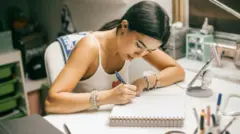 Mulher escrevendo em caderno