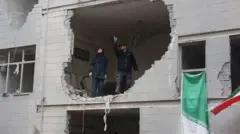 teheran, muškarac i žena stoje u zgradi razrušenoj u vazdušnom napadu