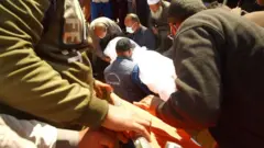 আবদেল মানাম মাহমুদ তার ভাইয়ের লাশ কবরে রাখছেন। যদিও তিনি নিশ্চিত নন, এটি তার ভাইয়েরই লাশ কিনা।