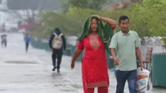 काठमाण्डूमा वर्षा भएपछि बाटोमा भिजेर हिँड्दै मानिसहरू 