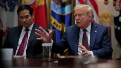 Donald Tramp govori za stolom. Američki državni sekretar Marko Rubio sedi pored njega.