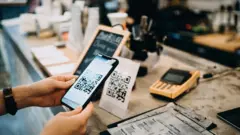 Pessoa realiza pagamento por meio de QR code