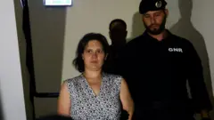 Francuzka Marine R. wychodząca w sobotę z sądu w Setúbal, eskortowana przez funkcjonariusza policji.